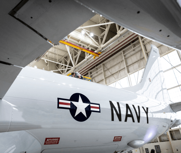 Mechanic on top of an airplane in a hangar Mechanic on top of an airplane in a hangar