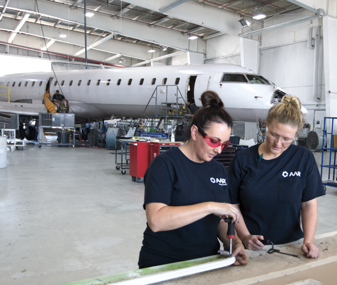 Two mechanics standing in front of an airplane Two mechanics standing in front of an airplane